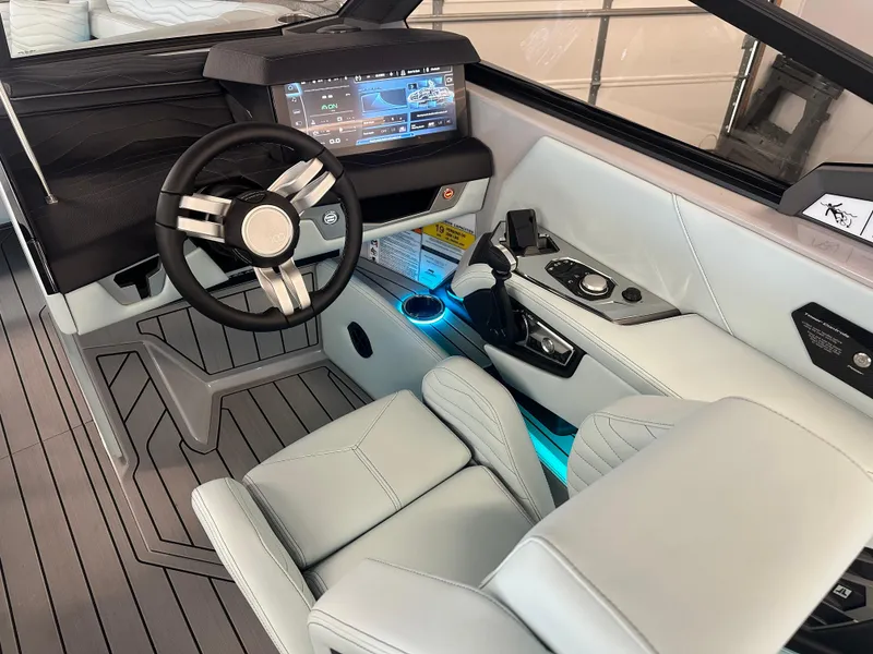 Slide: The Image of 2025 Nautique G25 boat interior with sleek seating and ambient blue lighting. - 13