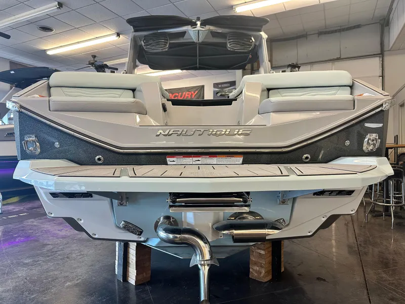 Slide: The Image of 2025 Nautique G25 boat rear view in showroom, showcasing sleek design and advanced features. - 2