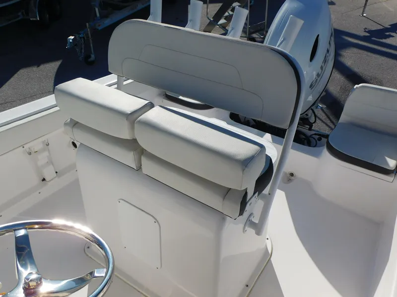 Slide: The Image of 2023 Clearwater 2200 WI Center Console boat interior with cushioned seating and steering wheel. - 20