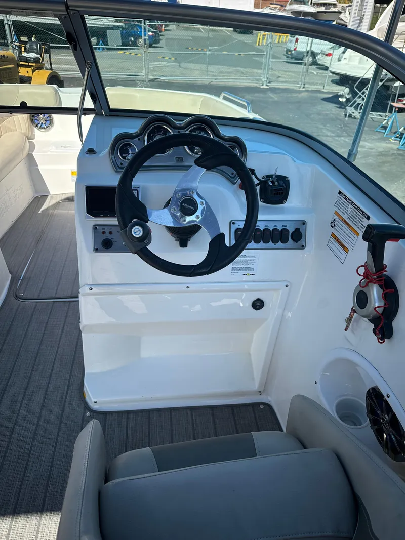 Slide: The Image of 2014 NauticStar 223DC Sport Deck boat cockpit with steering wheel and control panel. - 3