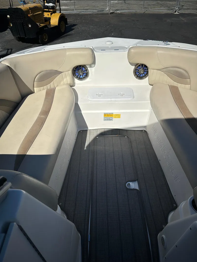 Slide: The Image of 2014 NauticStar 223DC Sport Deck boat interior with beige seating and speakers. - 6