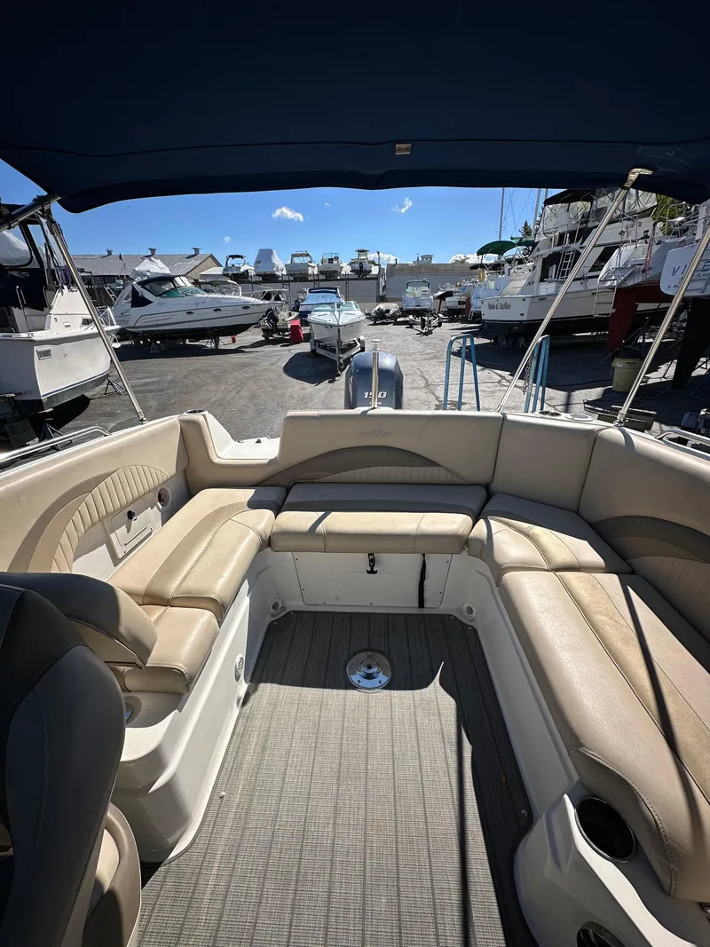 Slide: The Image of 2014 NauticStar 223DC Sport Deck boat with spacious seating, docked at a marina. - 8