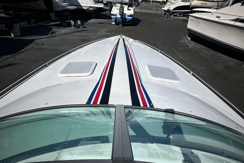 Slide: The Image of 2004 Formula 292 FASTech boat with sleek design and racing stripes in a marina. - 12