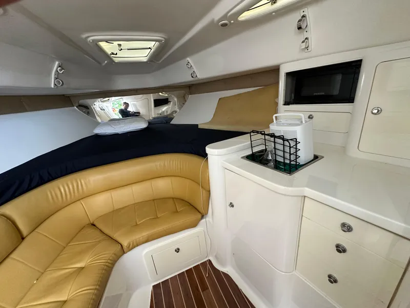 Slide: The Image of 2005 Intrepid 348 WA cabin interior with tan seating and kitchenette. - 10