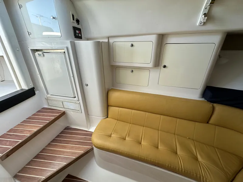 Slide: The Image of Interior of 2005 Intrepid 348 WA boat with yellow seating and storage cabinets. - 11