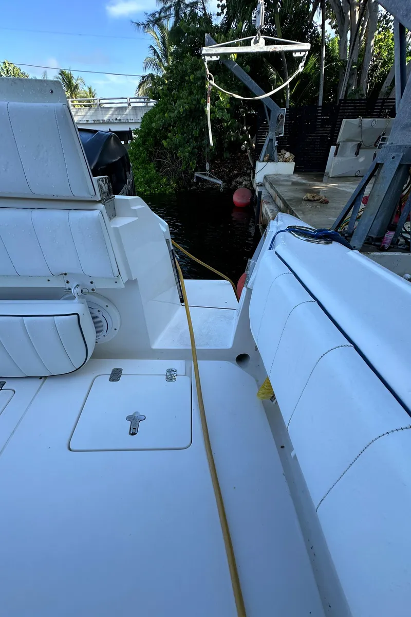 Slide: The Image of 2005 Intrepid 348 WA boat docked, featuring white seating and deck. - 17