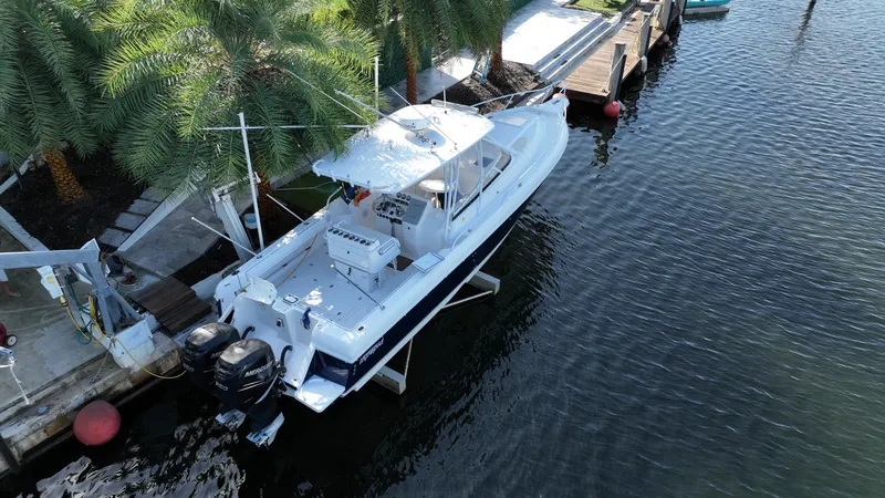 Slide: The Image of 2005 Intrepid 348 WA boat docked by palm trees, aerial view. - 2