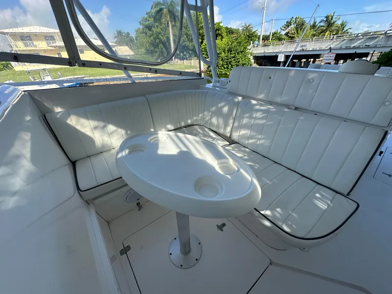 Slide: The Image of 2005 Intrepid 348 WA boat interior with white seating and round table. - 3