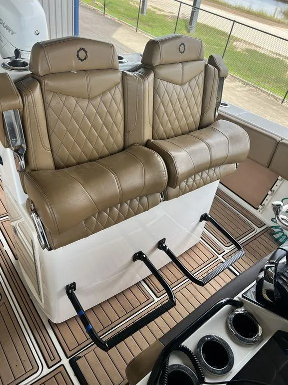 Slide: The Image of 2018 Fountain 38CC LS boat interior with tan leather seats and wood flooring. - 14