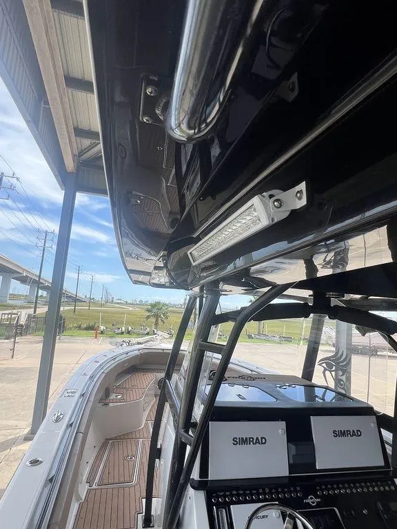 Slide: The Image of 2018 Fountain 38CC LS boat with Simrad electronics, docked under a canopy. - 35