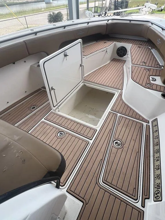 Slide: The Image of 2018 Fountain 38CC LS boat interior with open storage compartment and teak flooring. - 38