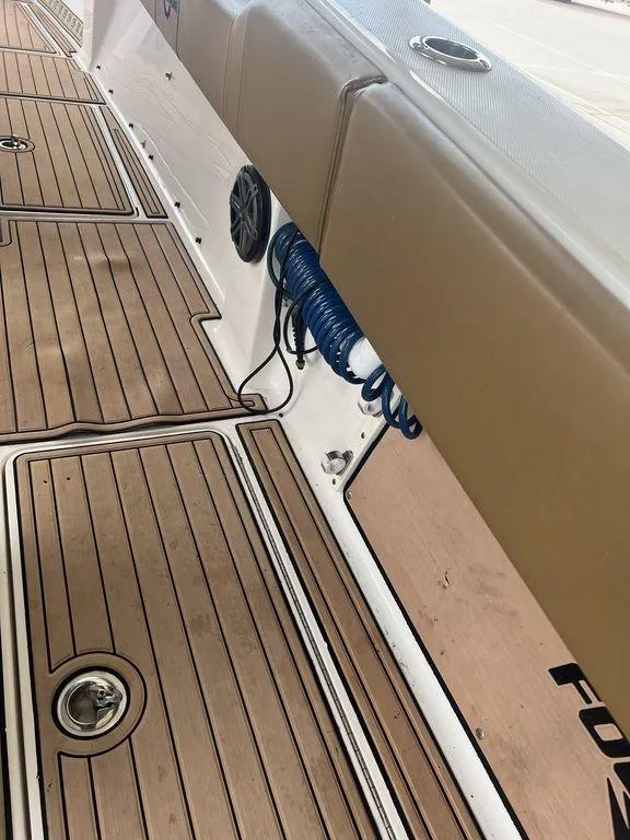 Slide: The Image of 2018 Fountain 38CC LS boat deck with teak flooring and coiled blue hose. - 43