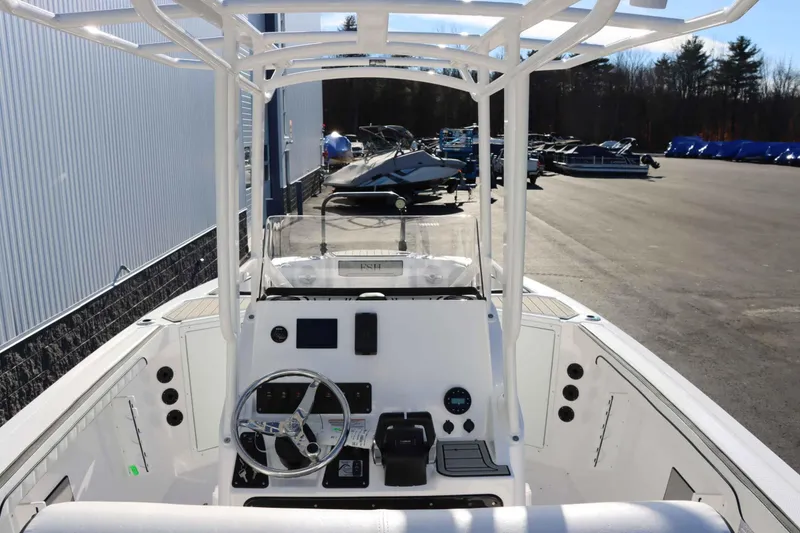 Slide: The Image of 2025 Yamaha Boats 222 FSH Sport, sleek white interior, parked outdoors. - 10