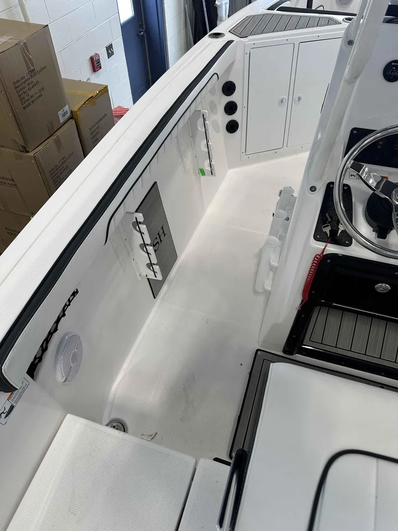 Slide: The Image of 2025 Yamaha Boats 222 FSH Sport interior, featuring steering wheel and storage compartments. - 15