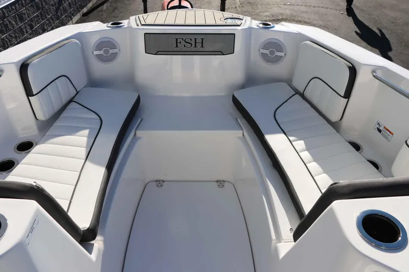 Slide: The Image of Interior view of 2025 Yamaha Boats 222 FSH Sport, featuring white seating and cup holders. - 19