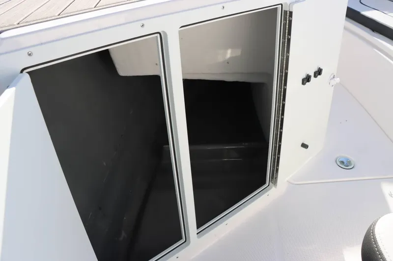 Slide: The Image of 2025 Yamaha Boats 222 FSH Sport storage compartment with open door. - 22