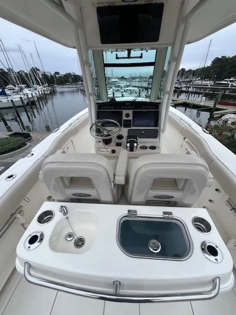 Slide: The Image of 2020 Boston Whaler 280 Outrage boat interior with helm and seating, docked at marina. - 16