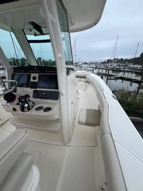 Slide: The Image of 2020 Boston Whaler 280 Outrage boat interior at marina, showcasing helm and seating. - 21