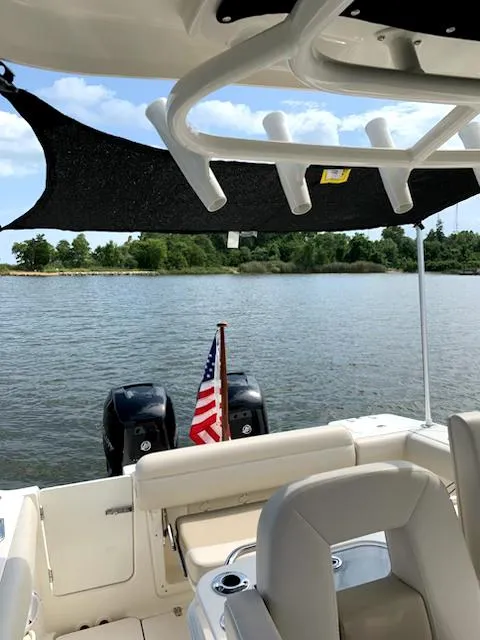 Slide: The Image of 2020 Boston Whaler 280 Outrage boat on water, featuring American flag and dual engines. - 30