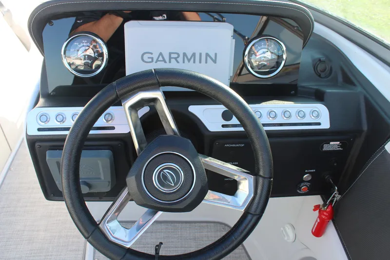 Slide: The Image of 2024 Crownline Eclipse E255 boat interior with steering wheel and seating. - 13