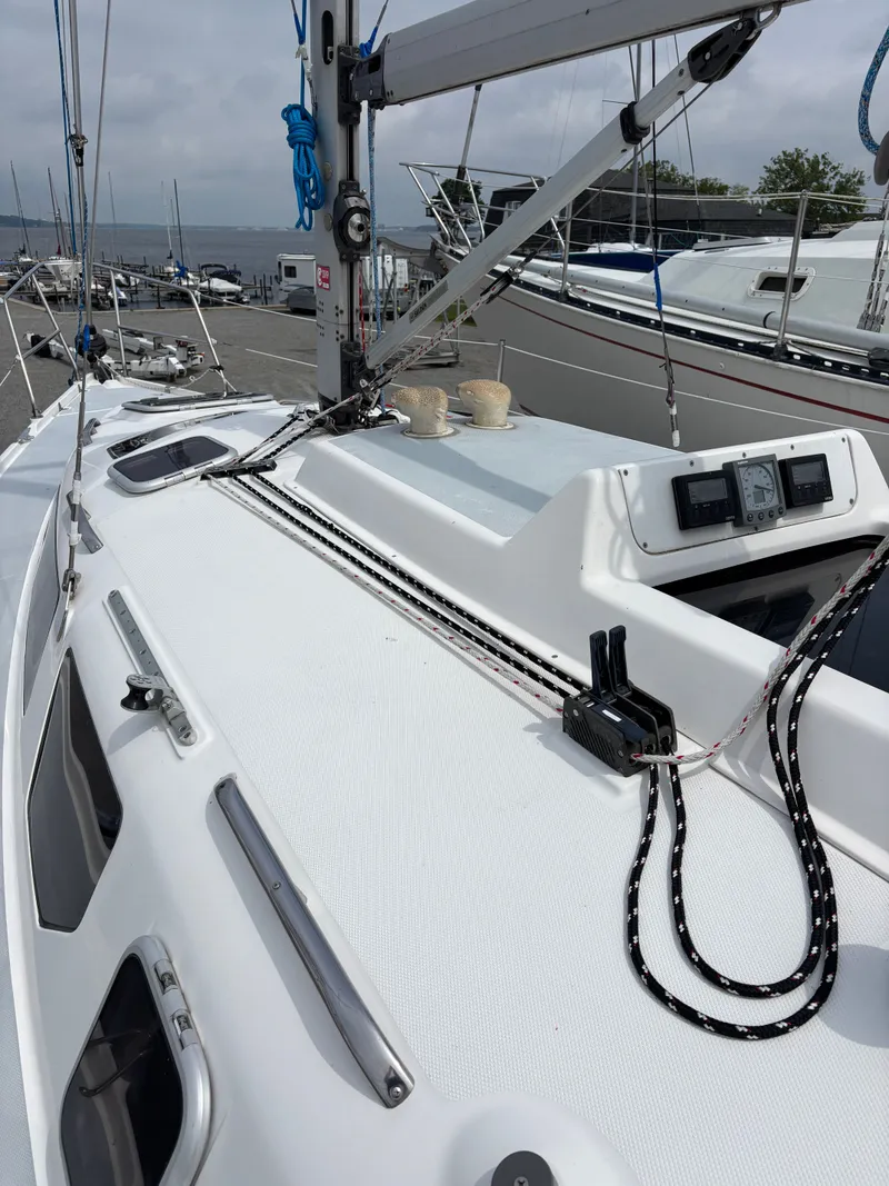 Slide: The Image of Sailboat deck of 2001 Hunter 320, featuring rigging and control panels at a marina. - 14