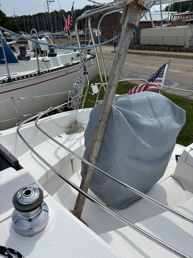 Slide: The Image of Sailboat deck of 2001 Hunter 320 with covered equipment and American flag. - 16