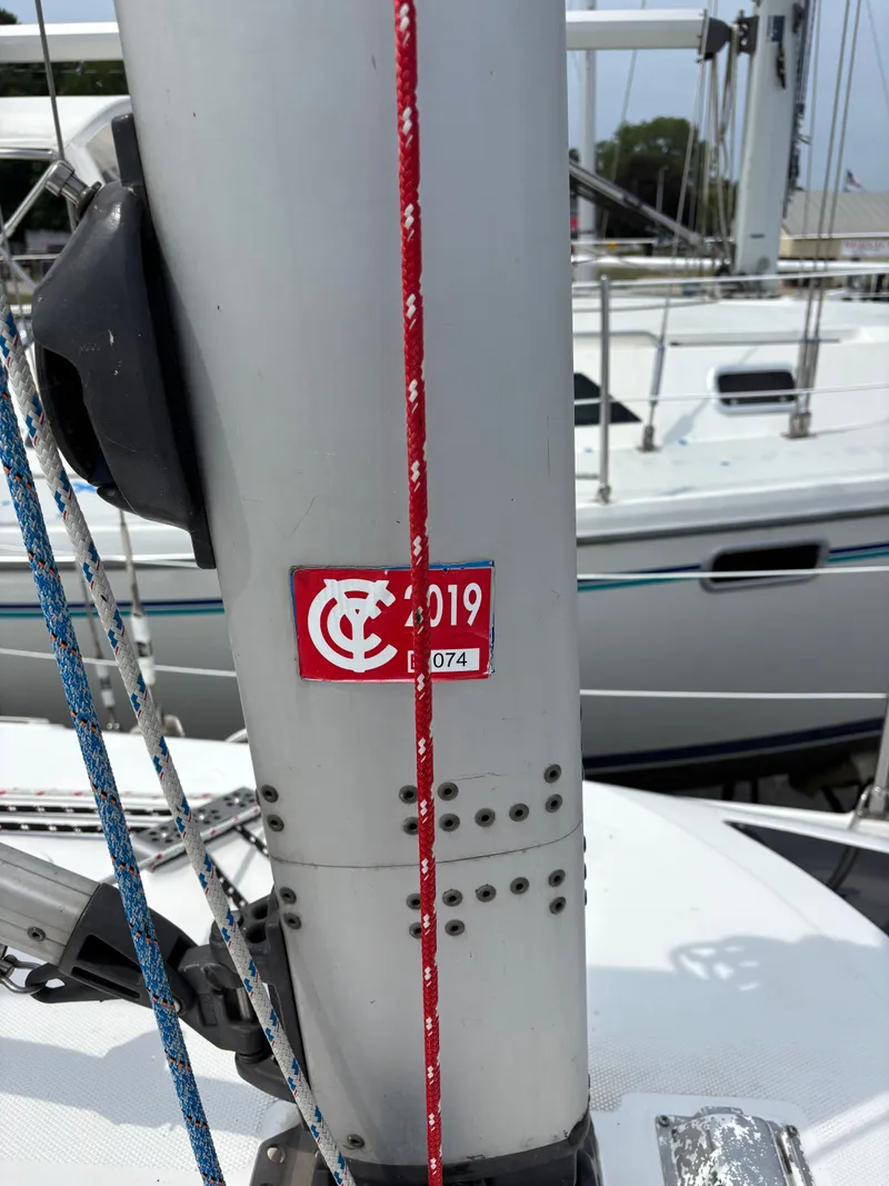 Slide: The Image of Mast of a 2001 Hunter 320 sailboat with red and blue ropes, docked. - 22