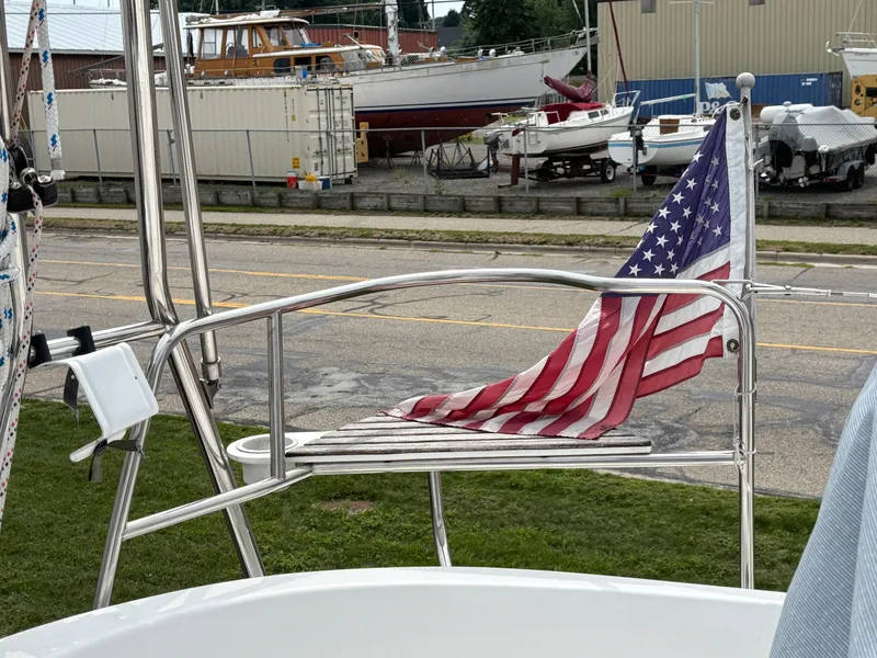 Slide: The Image of American flag on a 2001 Hunter 320 sailboat, docked near other boats. - 45