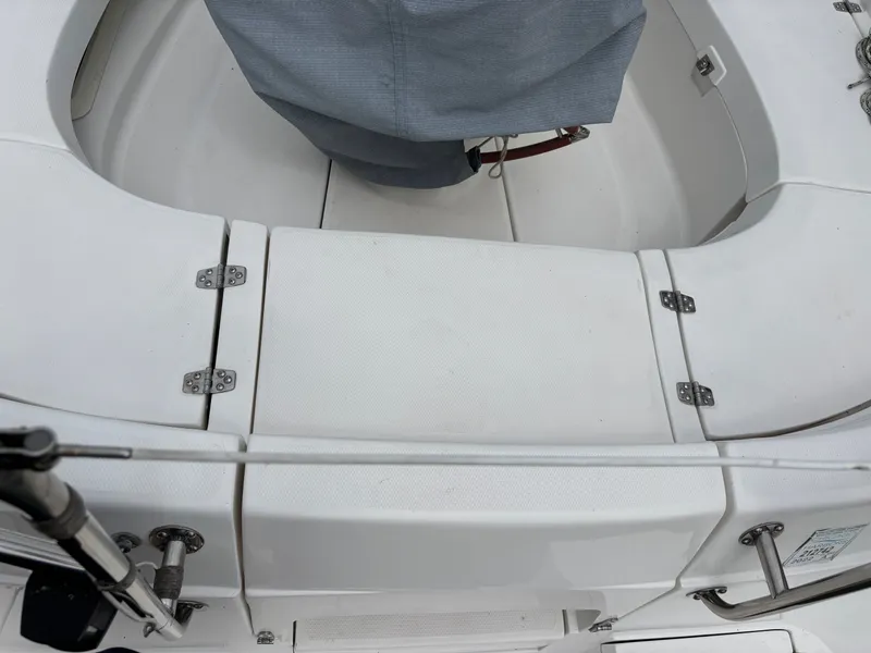 Slide: The Image of Cockpit of a 2001 Hunter 320 sailboat with covered equipment and white seating. - 46