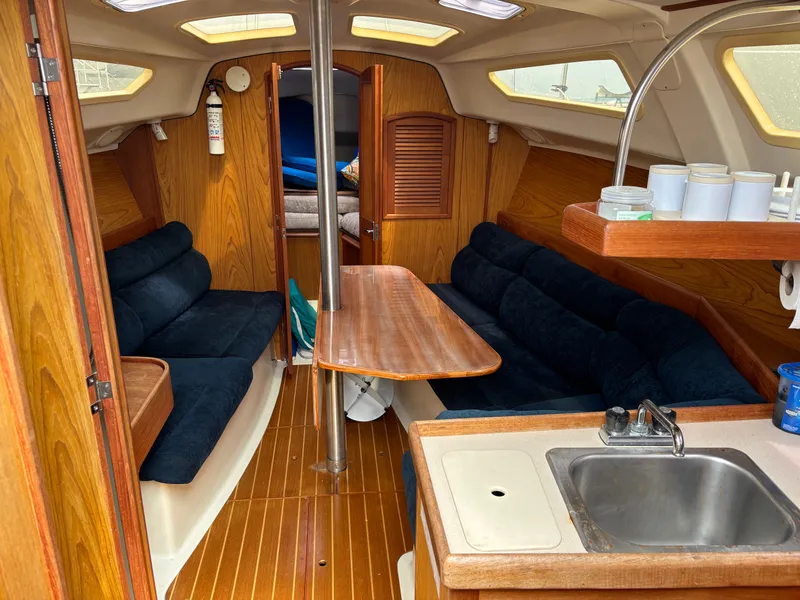Slide: The Image of Interior of a 2001 Hunter 320 sailboat with wood finish and blue seating. - 47