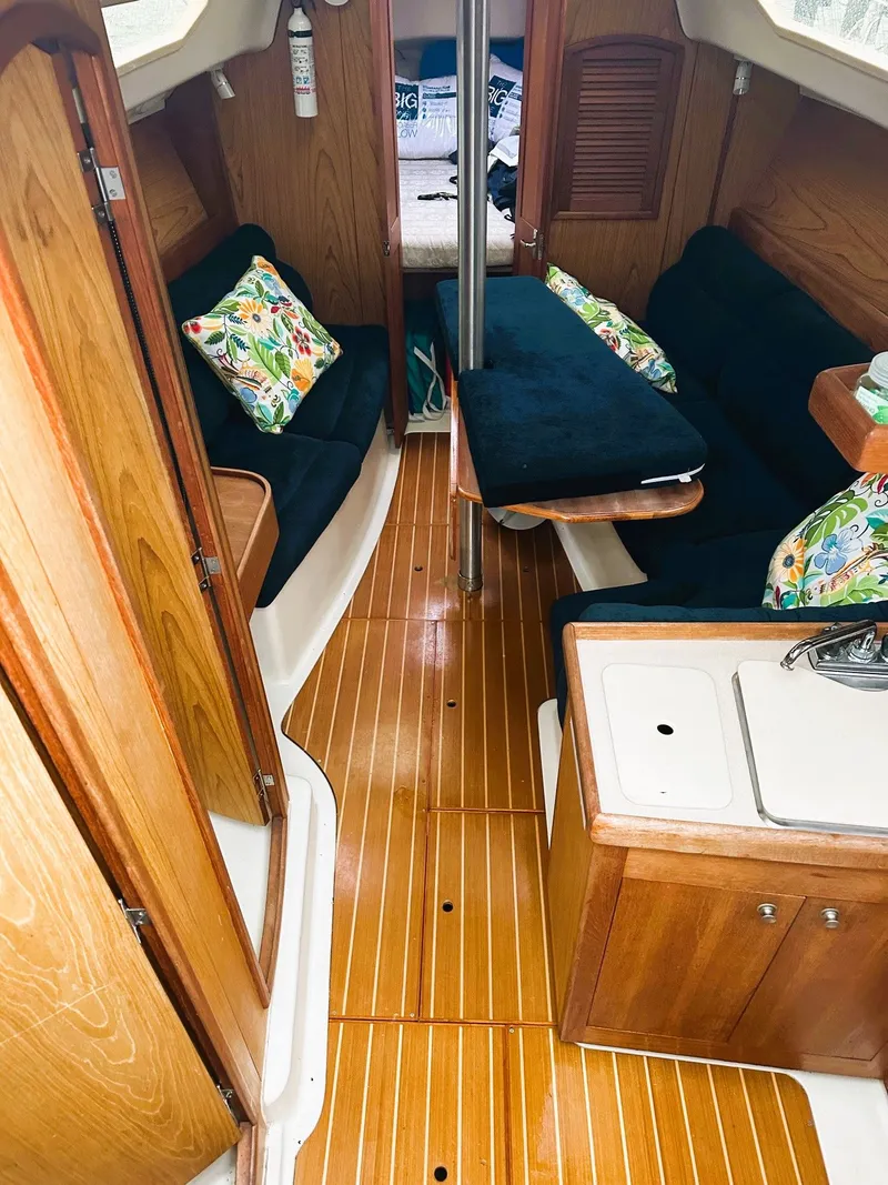 Slide: The Image of Interior of 2001 Hunter 320 sailboat with wood finish and cozy seating area. - 48