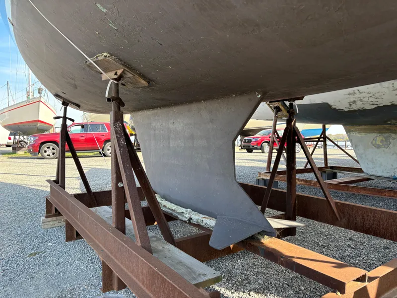 Slide: The Image of 2001 Hunter 320 sailboat keel on metal stands in a boatyard. - 7