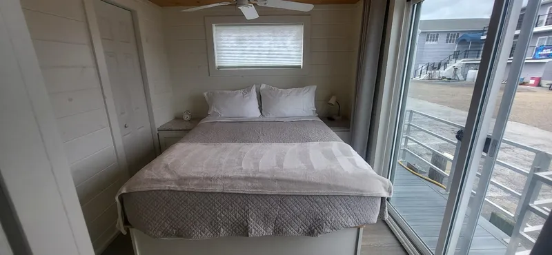 Slide: The Image of Bedroom interior of 2020 Destination Yachts 16x45 Condo Series with bed and sliding glass door. - 16
