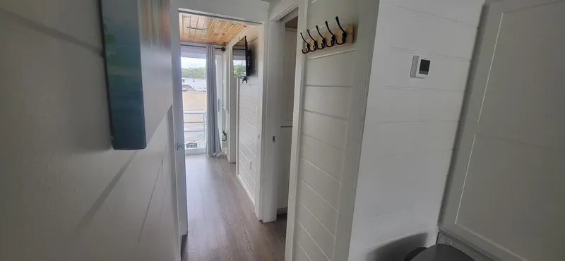 Slide: The Image of Interior hallway of 2020 Destination Yachts 16x45 Condo Series, featuring modern design and wood flooring. - 19