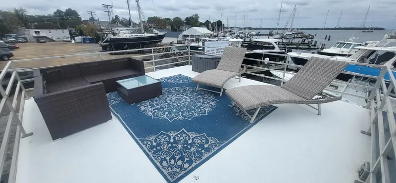Slide: The Image of 2020 Destination Yachts 16x45 Condo Series rooftop deck with lounge chairs and blue rug. - 25