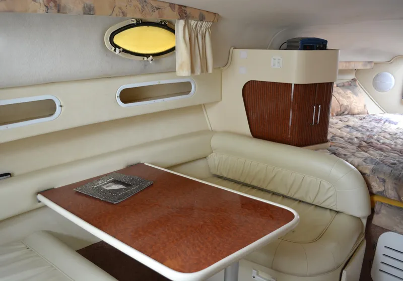 Slide: The Image of Interior of 1998 Monterey 296 Cruiser with beige seating and wooden table. - 7