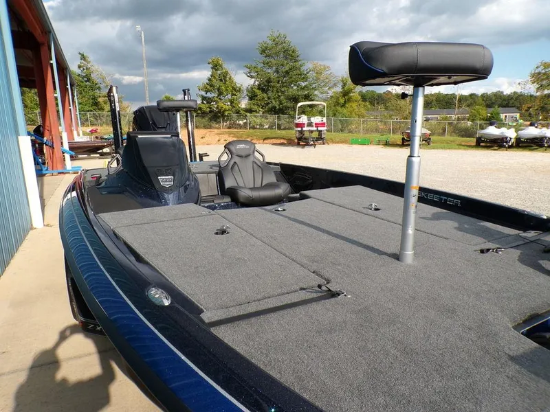 Slide: The Image of 2025 Skeeter ZXR20 fishing boat with spacious deck and seating, parked outdoors. - 13
