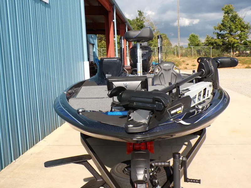 Slide: The Image of 2025 Skeeter ZXR20 fishing boat parked outside a blue building. - 2