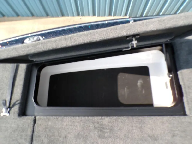 Slide: The Image of Storage compartment of 2025 Skeeter ZXR20 boat, open lid, carpeted interior. - 21