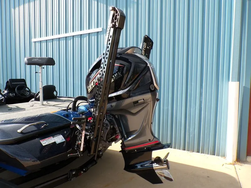Slide: The Image of 2025 Skeeter ZXR20 boat with powerful outboard motor, parked near a blue metal wall. - 6