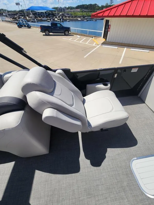 Slide: The Image of 2024 Sylvan Mirage X3 boat interior with reclining seats at a marina. - 10