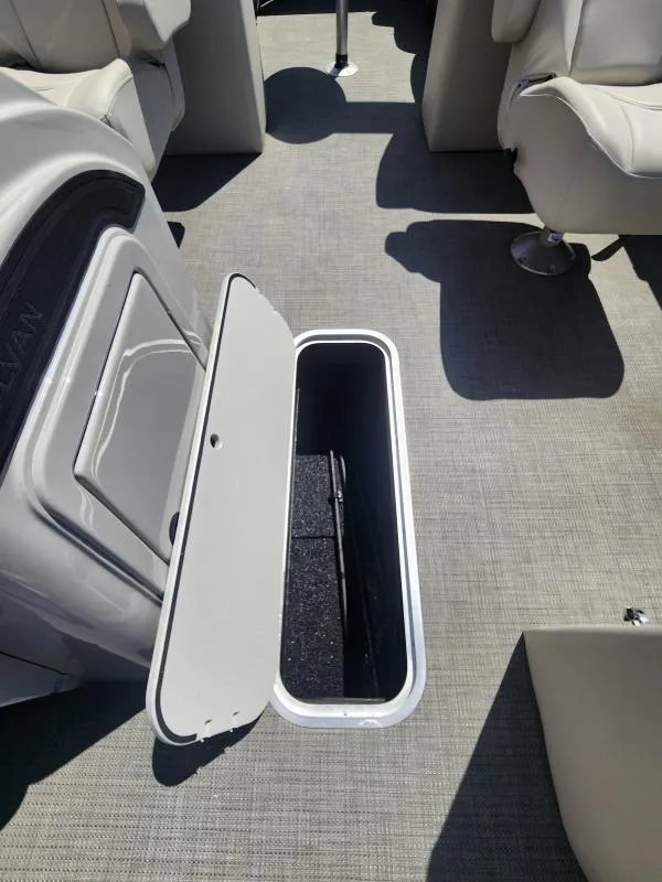Slide: The Image of 2024 Sylvan Mirage X3 boat interior with open storage compartment and seating. - 17