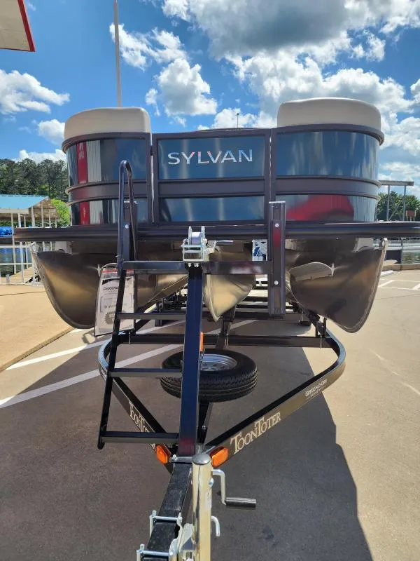 Slide: The Image of 2024 Sylvan Mirage X3 pontoon boat on trailer under a sunny sky. - 4