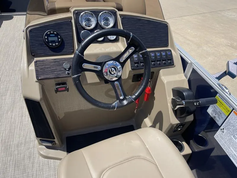 Slide: The Image of 2024 Sylvan Mirage 8524 LZ boat dashboard with steering wheel and controls. - 12