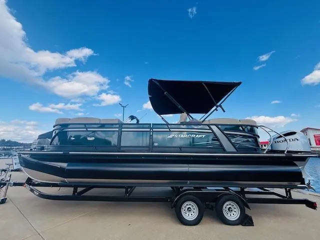 Slide: The Image of 2024 Starcraft SLS-3 pontoon boat on trailer, under blue sky. - 3