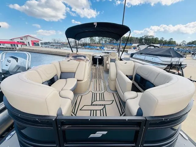 Slide: The Image of 2024 Starcraft SLS-3 pontoon boat with spacious seating at a marina. - 9