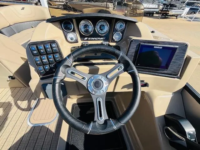 Slide: The Image of 2024 Starcraft SLS-3 boat dashboard with steering wheel, controls, and navigation display. - 10