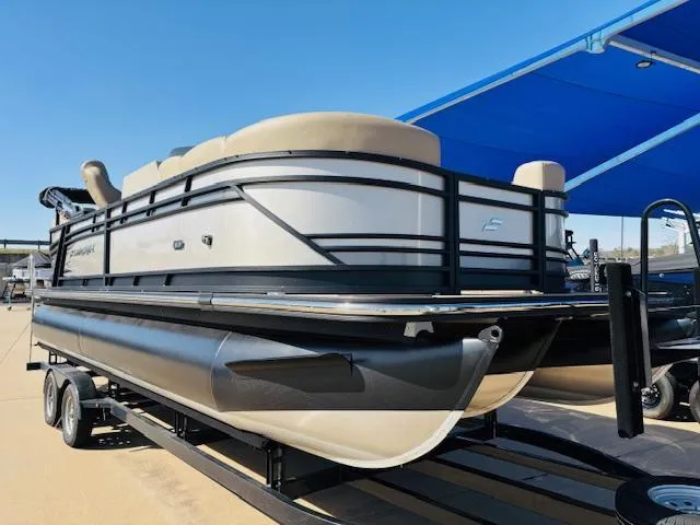 Slide: The Image of 2024 Starcraft SLS-3 pontoon boat on trailer under blue canopy. - 3