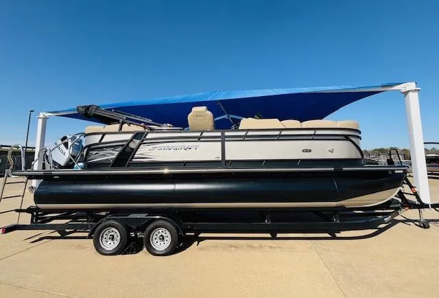 Slide: The Image of 2024 Starcraft SLS-3 pontoon boat on trailer under blue canopy. - 4