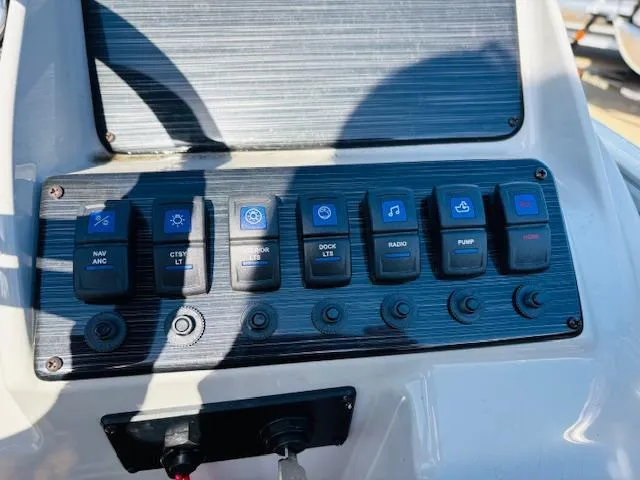 Slide: The Image of Control panel of 2024 Sylvan Mirage 8522 LZ boat with labeled switches. - 16